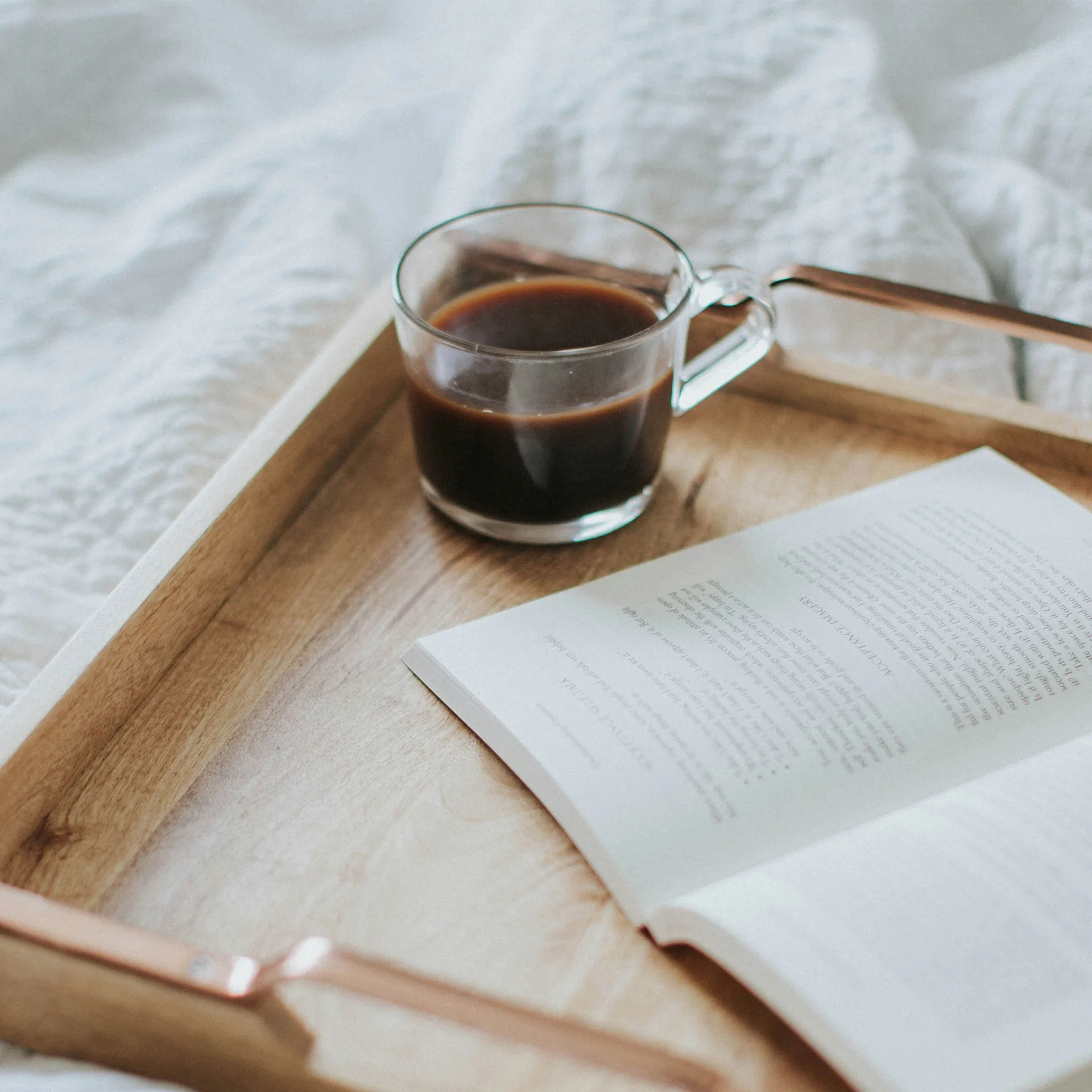 Kaffe och bok på en bricka